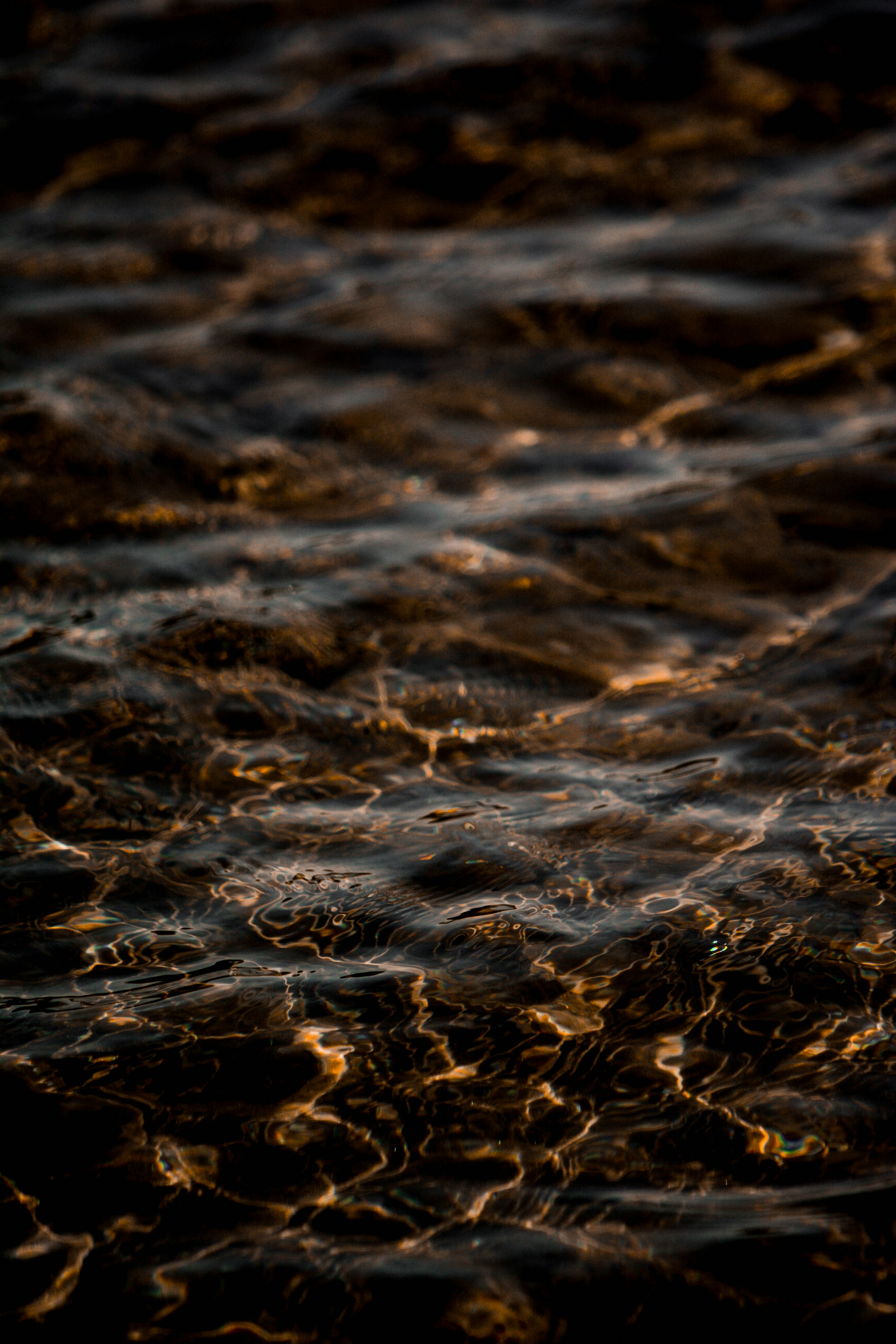 water wave on brown sand during daytime